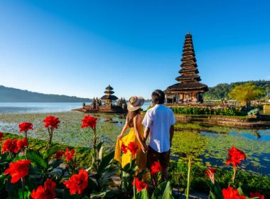 Young couple tourist relaxing and enjoying the beautiful view at Ulun Danu Beratan temple in Bali, Indonesia